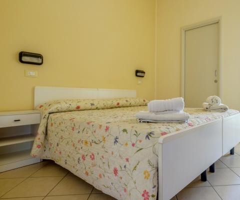 Helles Zimmer mit Blumenbettdecke und weichen Handtüchern.