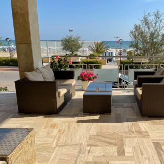 Terrazza con sedie in rattan e vista mare.