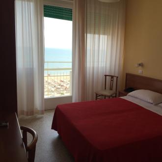Camera d'hotel con vista mare, letto matrimoniale.