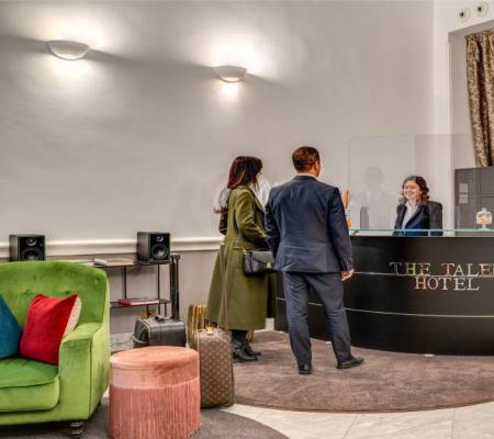 Hotel reception with guests and modern decor.