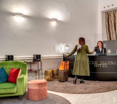 Hotel reception with guests and welcoming staff.
