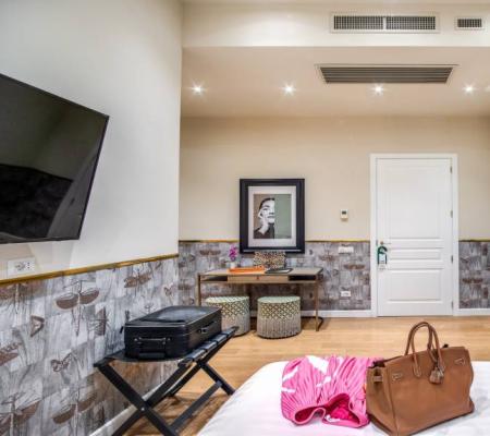 Elegant hotel room with suitcase and bag on the bed.