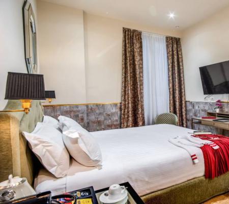 Elegant hotel room with double bed and TV.