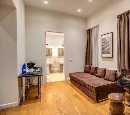 Modern living room with sofa, table, and bathroom access.
