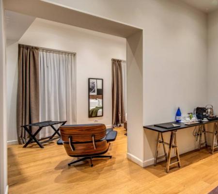 Modern room with chair, desk, and bathroom.