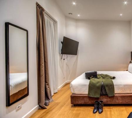 Modern room with bed, TV, and elegant decor.