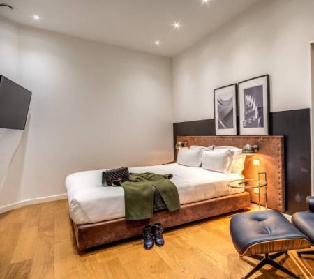 Modern room with bed, chair, and elegant decor.