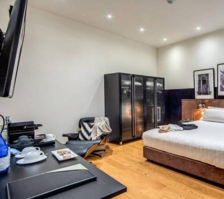Modern room with double bed, wardrobe, and desk.