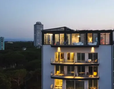 Edificio moderno al tramonto con luci accese e balconi.