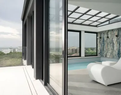 Piscina interna con vista panoramica e arredi moderni.