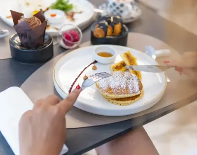 Pancake con zucchero a velo e sciroppo su un piatto elegante.