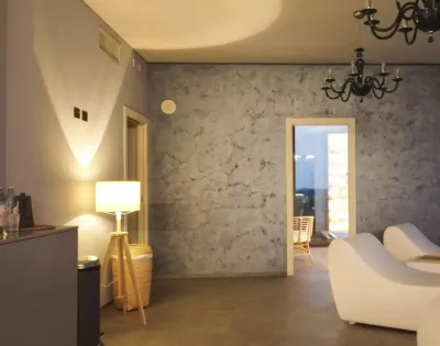Salotto moderno con poltrone bianche e lampadario nero.
