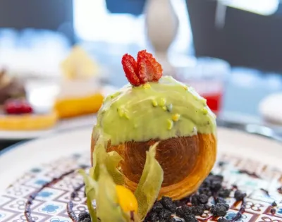 Dessert con glassa verde, fragola e frutta esotica.
