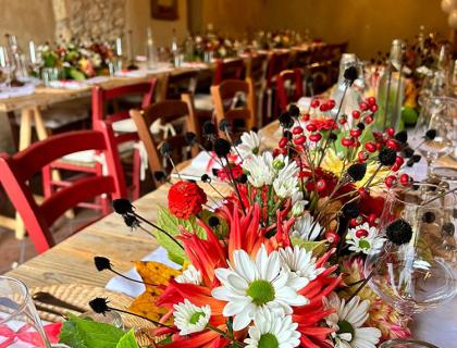Tavola decorata con fiori autunnali colorati in una sala da pranzo accogliente.