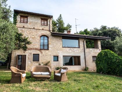 Casa in pietra con giardino e mobili da esterno.