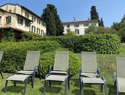 Sedie a sdraio su un prato davanti a una villa.