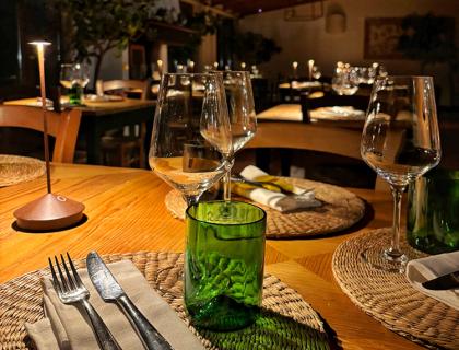 Ristorante elegante con bicchieri e posate su tavoli apparecchiati.