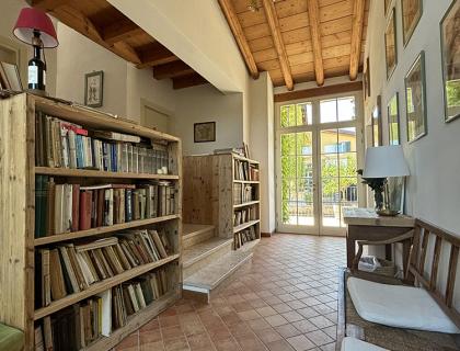 Corridoio rustico con scaffali di libri e soffitto in legno.