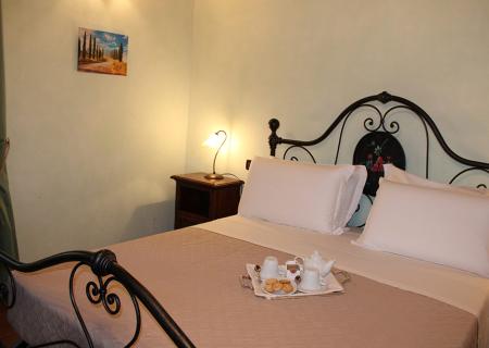 Camera accogliente con letto elegante e colazione servita, atmosfera calda e rilassante.