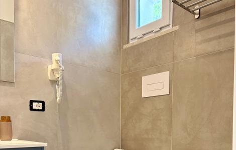 Bagno moderno e luminoso, piastrelle grigie e sanitari bianchi eleganti.