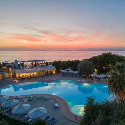 Tramonto mozzafiato su piscina e mare, atmosfera di relax e serenità.