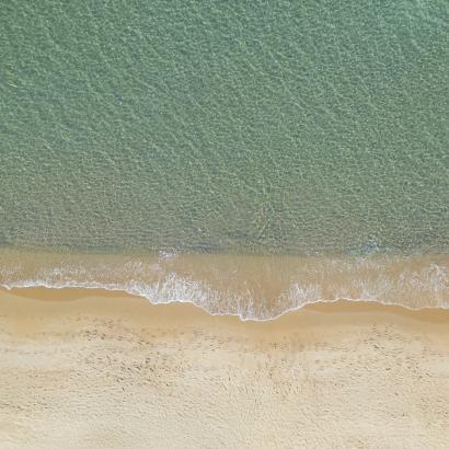 Spiaggia serena, onde delicate, sabbia dorata, pace e tranquillità.