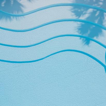 Piscina azzurra con onde sinuose e ombre di palme, atmosfera rilassante.
