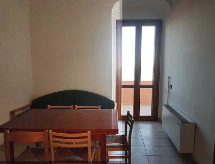 Sala da pranzo semplice, luce soffusa, atmosfera tranquilla e accogliente.