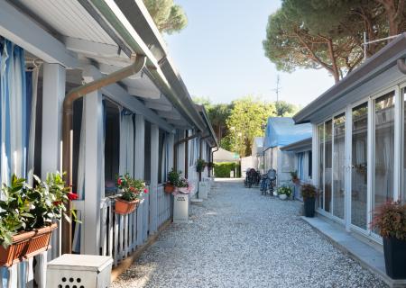 Bungalow path with colorful flowers and bikes, serene and welcoming atmosphere.