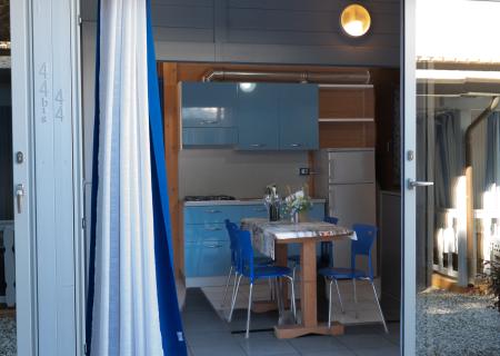 Cozy kitchen with blue cabinets, set table, and warm lighting.