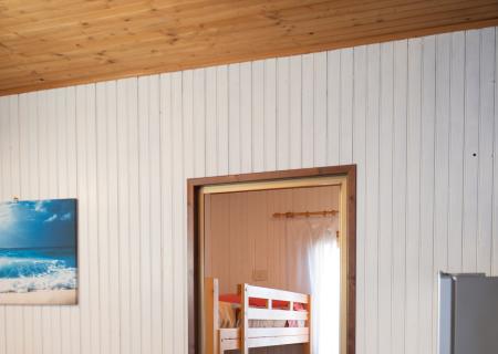 Cozy room with bunk beds, kitchen, rustic table, warm and homely atmosphere.