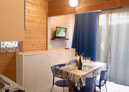 Cozy wooden dining room, set table, TV on.