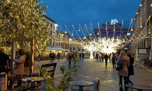 Piazza illuminata con decorazioni natalizie e albero di Natale.