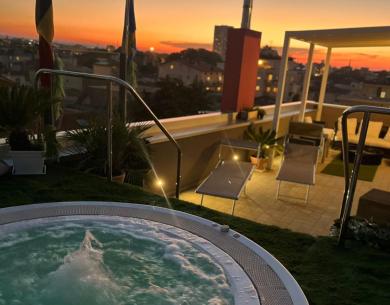 Coucher de soleil sur terrasse avec jacuzzi, ambiance relaxante et vue imprenable.