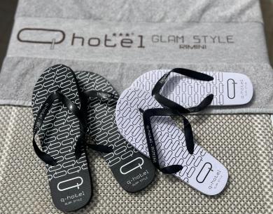 Elegante Flip-Flops auf Hoteltuch, entspannte und schicke Atmosphäre.