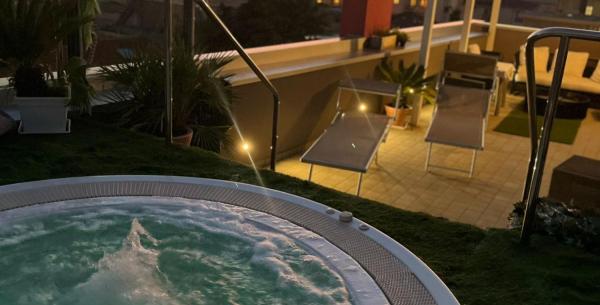 Coucher de soleil sur terrasse avec jacuzzi, ambiance relaxante et vue imprenable.