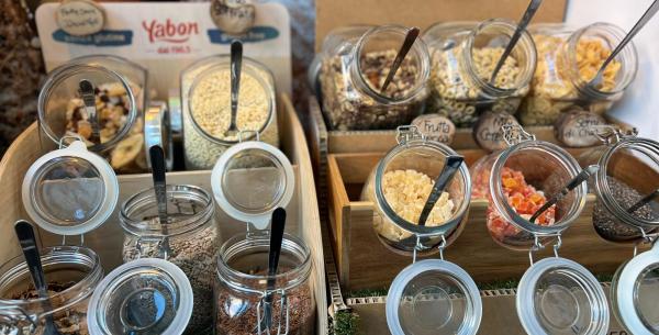 Barattoli di cereali e frutta secca, colorati e invitanti.