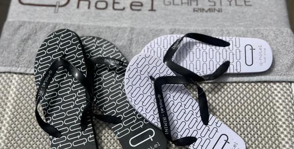 Elegante Flip-Flops auf Hoteltuch, entspannte und schicke Atmosphäre.