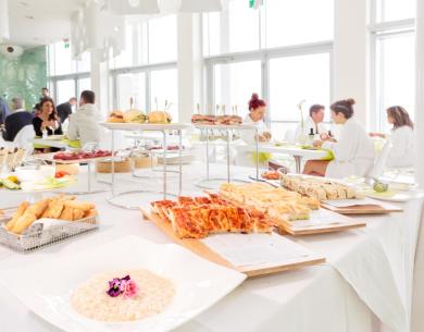 Buffet avec pizzas et sandwichs dans un restaurant lumineux.