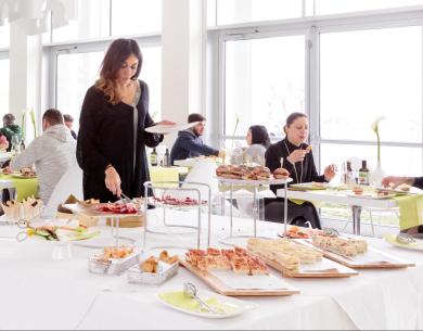 Buffet in un ristorante moderno con persone che si servono.