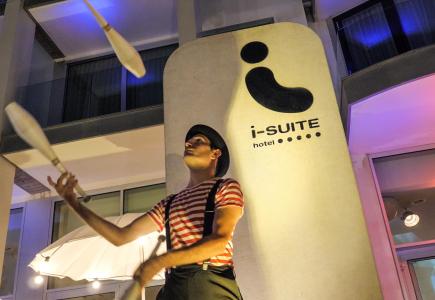 Giocoliere affascinante davanti all'hotel illuminato di notte, atmosfera magica.
