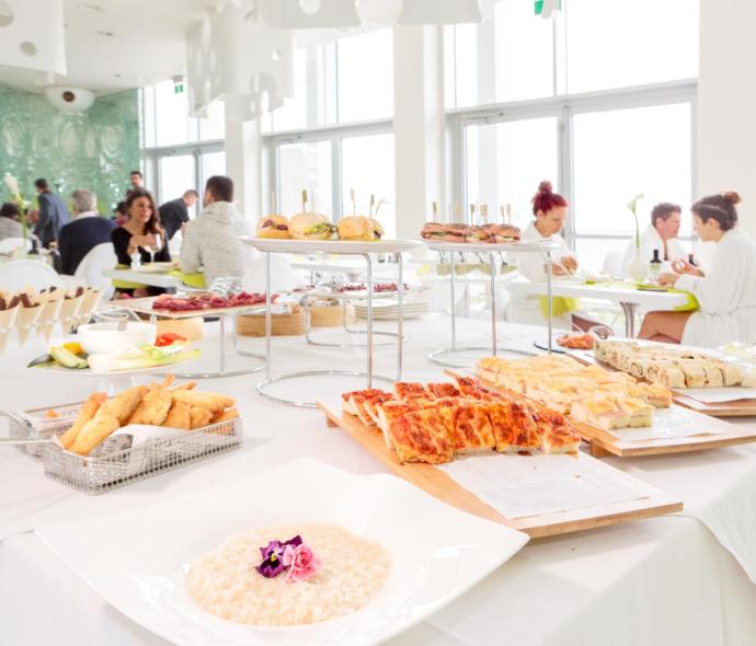 Buffet with pizzas and sandwiches in a bright restaurant.