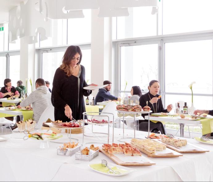 Buffet in un ristorante moderno con persone che si servono.