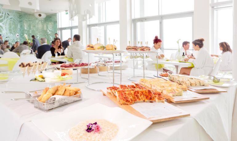 Buffet with pizzas and sandwiches in a bright restaurant.