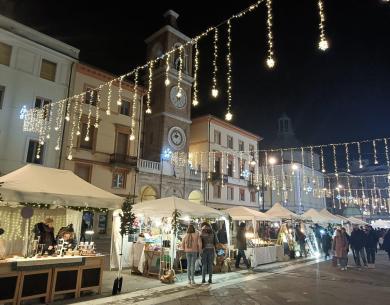 Mercatino di Natale con luci e bancarelle in piazza.