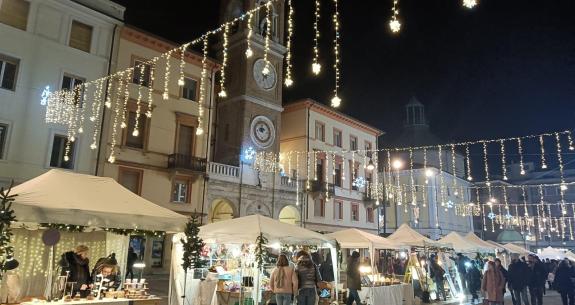 Mercatino di Natale con luci e bancarelle in piazza.