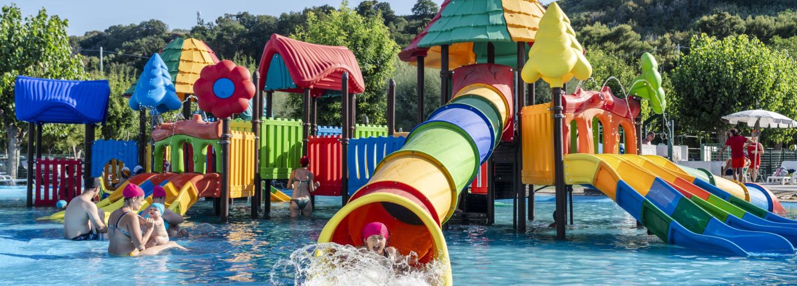 Parco acquatico colorato con scivoli e giochi per bambini.