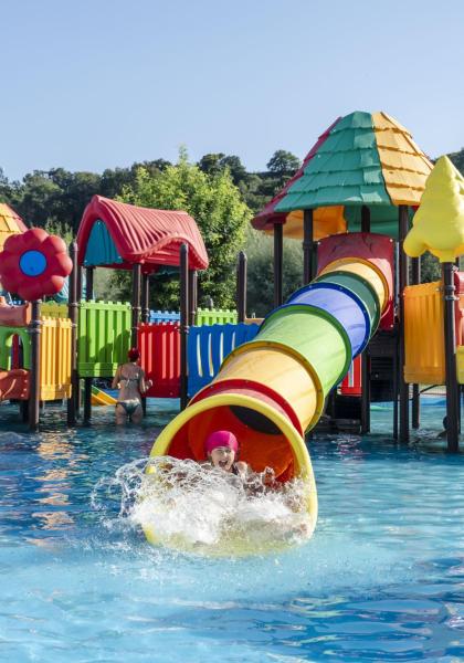 Parco acquatico colorato con scivoli e giochi per bambini.