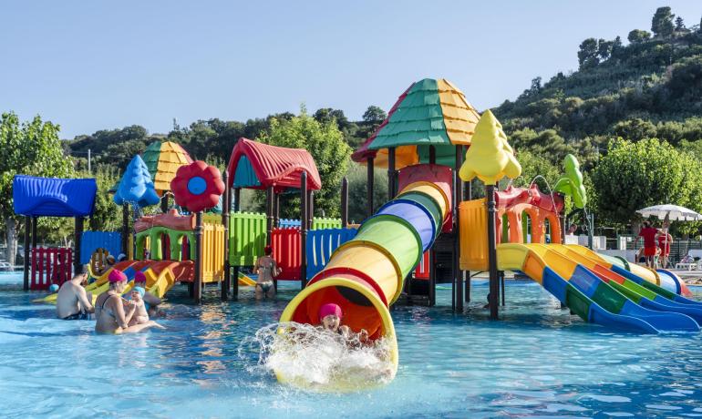 Parco acquatico colorato con scivoli e giochi per bambini.