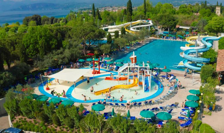 Wasserpark mit Pools, Rutschen und Grünflächen, Blick auf den See.